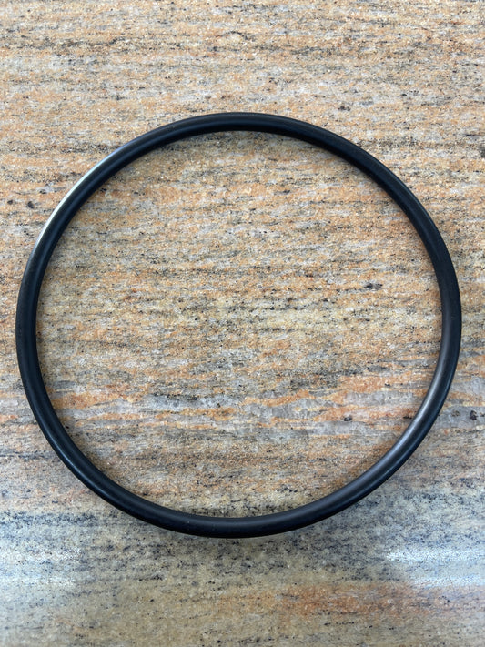 Black EPDM replacement O-ring for a pond leaf trap lid, lying flat on a wooden surface