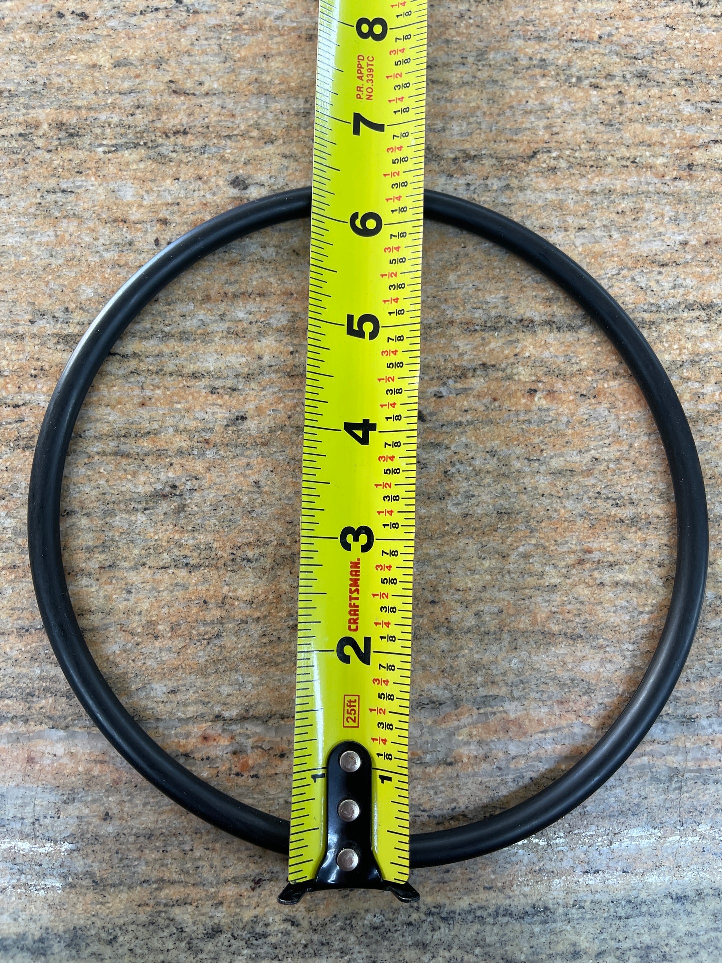 EPDM leaf trap lid O-ring with a tape measure laid across it to show the outside diameter, smaller of the two sizes