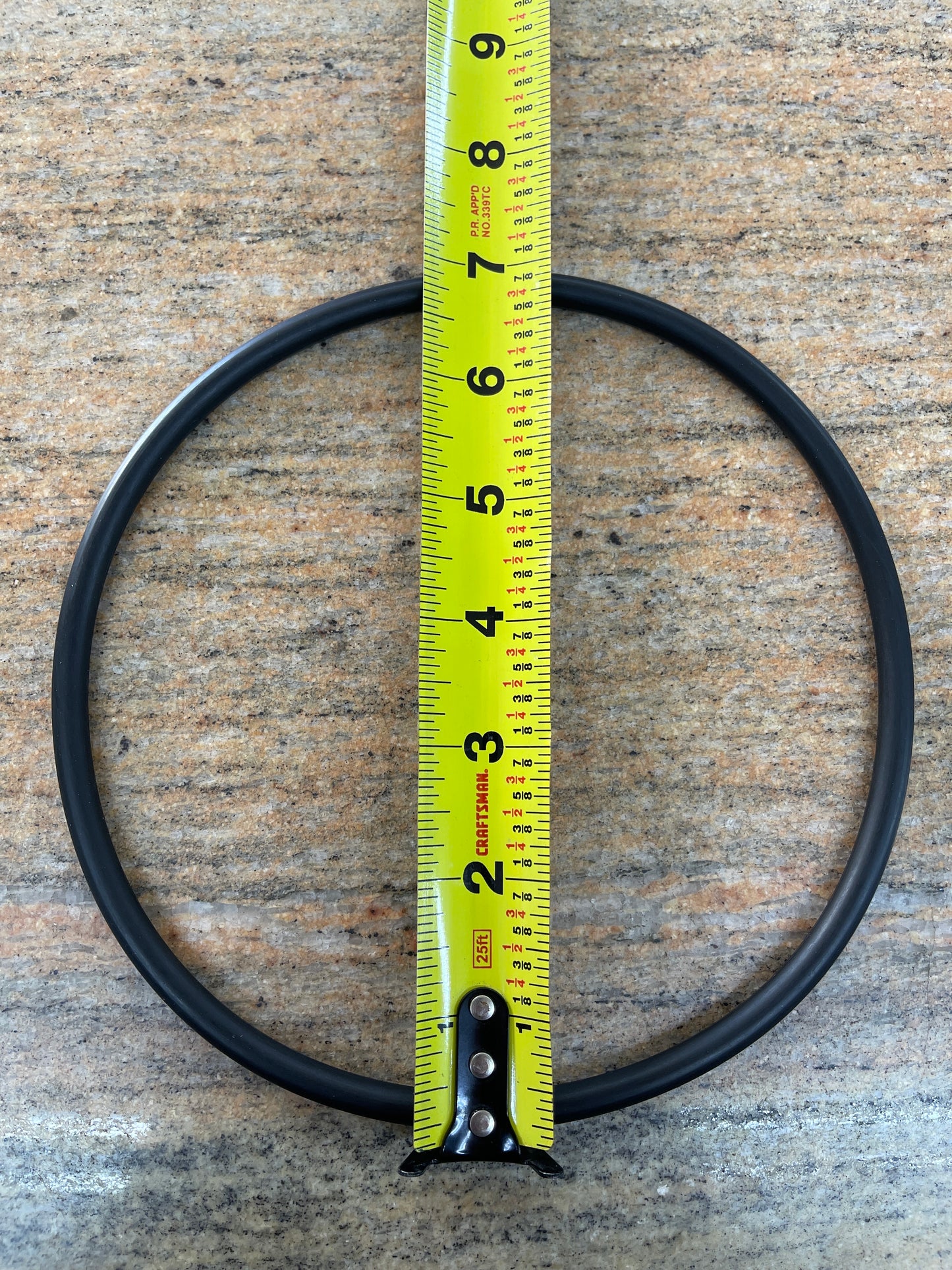 EPDM leaf trap lid O-ring with a tape measure laid across it to show the outside diameter, larger of the two sizes